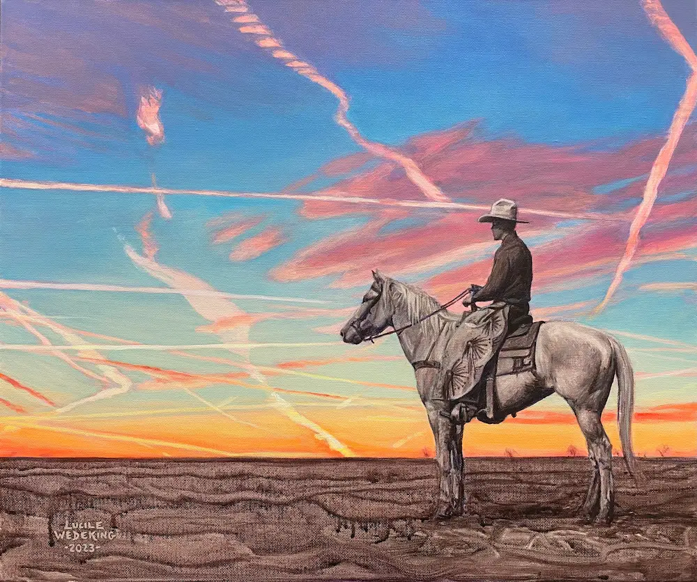 Monochrome desert landscape and cowboy on horseback with a vibrant and colorful sunset