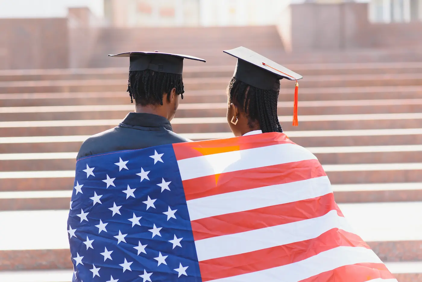 Graduates with american flag wrapped around them.
