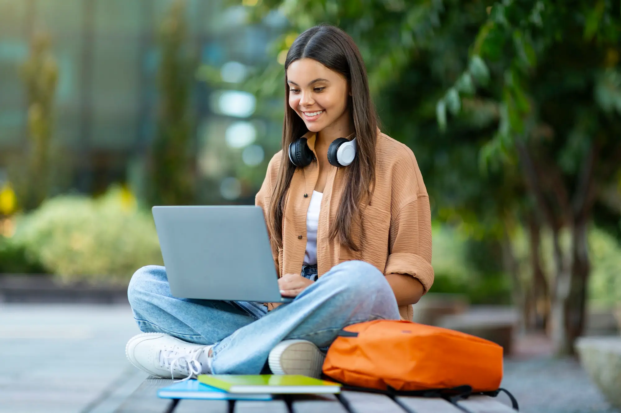 Smiling student registering for spring classes on laptop