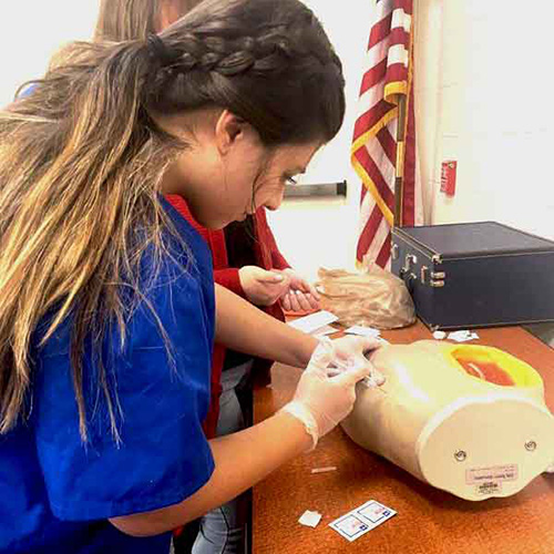 Jenny Duran is doing a venipuncture to obtain blood for testing.